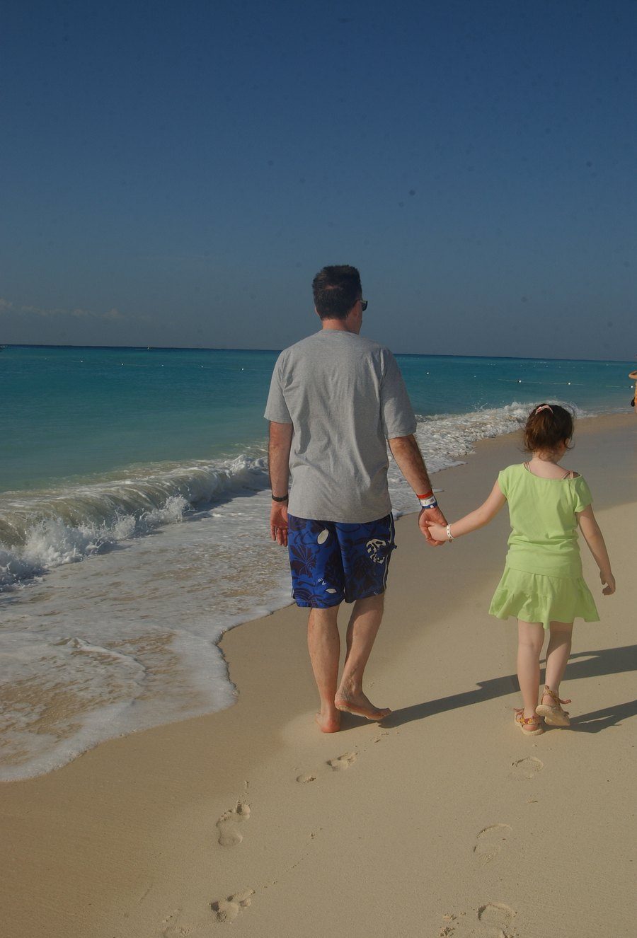 Tim O'Brien walking the shoreline with Anna Christine O'Brien, Playa del Carmen, Mexico, 2005